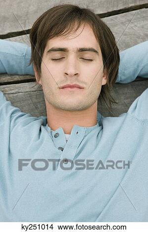 Man resting on a boardwalk View Large Photo Image Picture - Man resting on a boardwalk. Fotosearch