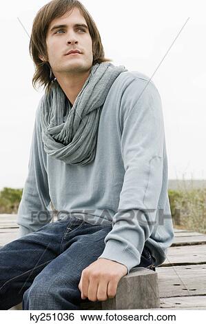Man sitting on a boardwalk View Large Photo Image Stock Photograph - Man sitting on a boardwalk. Fotosearch