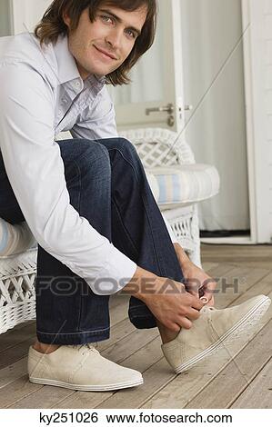 Man tying his shoelaces View Large Photo Image Stock Photograph - Man tying his shoelaces. Fotosearch