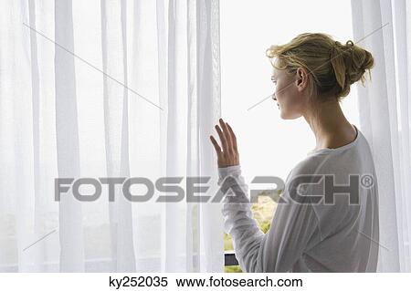 Rear view of a woman standing on balcony View Large Photo Image Stock Photography - Rear view of a woman standing on balcony. Fotosearch