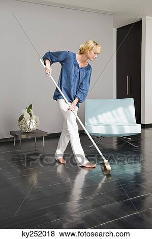 Woman cleaning floor with a mop View Large Photo Image Stock Photo - Woman cleaning floor with a mop. Fotosearch
