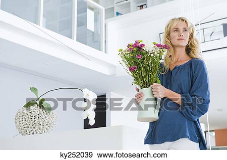 Stock Photo - Woman holding a flower pot. Fotosearch