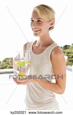 Woman holding a jug of lemonade and smiling View Large Photo Image Stock Image - Woman holding a jug of lemonade and smiling. Fotosearch