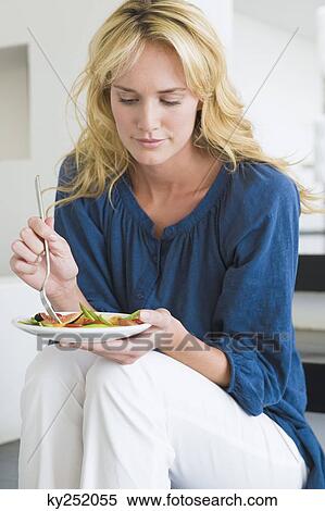 Stock Photography - Woman holding a plate of fruit salad. Fotosearch
