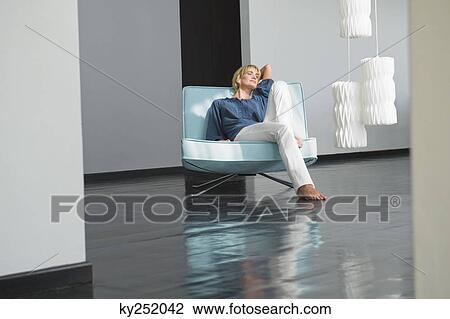 Woman reclining on a couch View Large Photo Image Stock Image - Woman reclining on a couch. Fotosearch