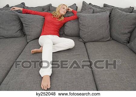 Woman reclining on a couch View Large Photo Image Stock Photo - Woman reclining on a couch. Fotosearch
