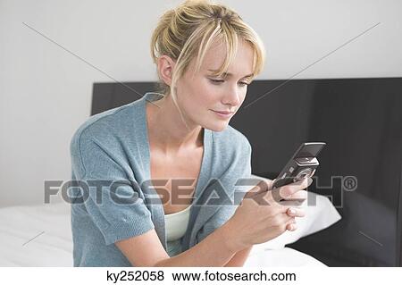Stock Photo - Woman text messaging on a mobile phone. Fotosearch