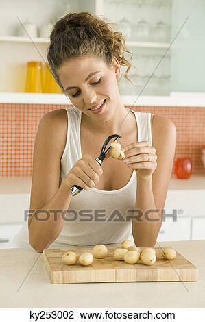 Close-up of a woman peeling potatoes View Large Photo Image Stock Image - Close-up of a woman peeling potatoes. Fotosearch