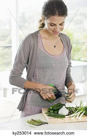 Picture - Woman chopping vegetables in the kitchen. Fotosearch