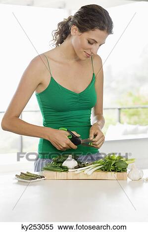 Woman chopping vegetables in the kitchen View Large Photo Image Stock Photography - Woman chopping vegetables in the kitchen. Fotosearch