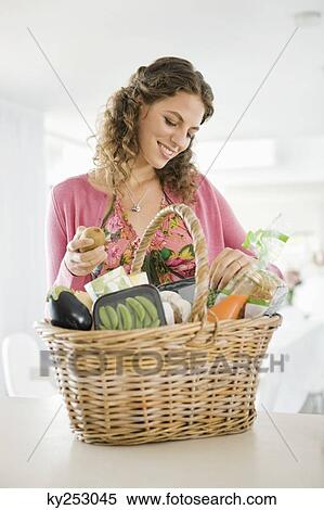 Woman holding a basket in the kitchen View Large Photo Image Stock Photography - Woman holding a basket in the kitchen. Fotosearch