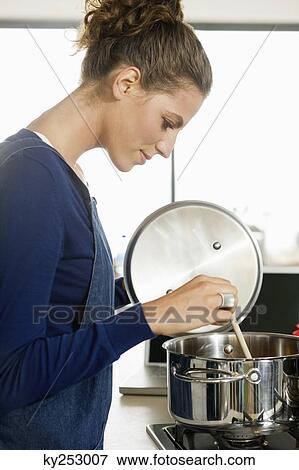 Woman preparing food in the kitchen View Large Photo Image Stock Photo - Woman preparing food in the kitchen. Fotosearch
