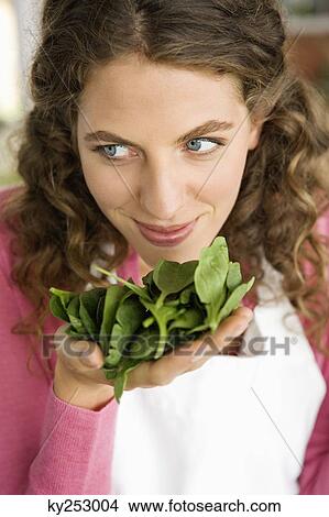 Woman smelling spinach leaves in the kitchen View Large Photo Image Picture - Woman smelling spinach leaves in the kitchen. Fotosearch
