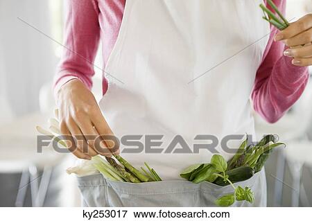 Woman standing with vegetables in the kitchen View Large Photo Image Stock Photo - Woman standing with vegetables in the kitchen. Fotosearch
