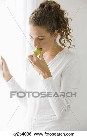 Close-up of a woman eating fruit View Large Photo Image Stock Photograph - Close-up of a woman eating fruit. Fotosearch