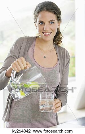 Portrait of a woman pouring lemonade into a glass View Large Photo Image Stock Image - Portrait of a woman pouring lemonade into a glass. Fotosearch