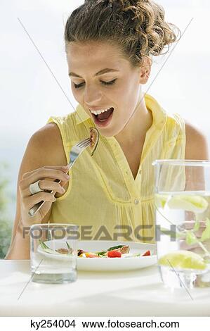 Woman eating fruit salad View Large Photo Image Picture - Woman eating fruit salad. Fotosearch