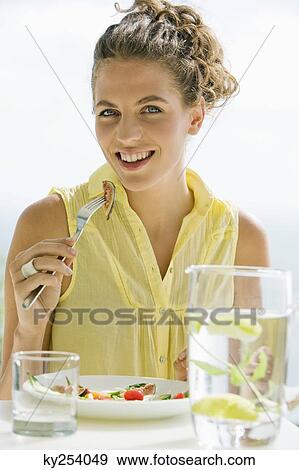 Woman eating fruit salad View Large Photo Image Stock Photo - Woman eating fruit salad. Fotosearch