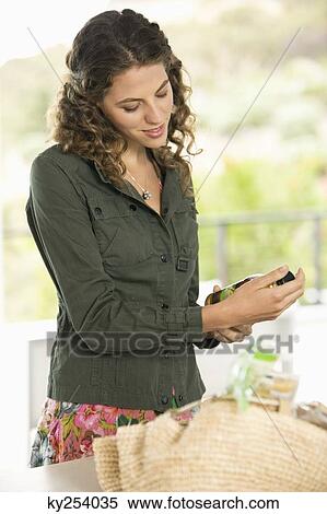 Woman holding a bottle in the kitchen View Large Photo Image Stock Photography - Woman holding a bottle in the kitchen. Fotosearch