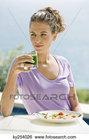 Woman holding a glass of pea soup View Large Photo Image Stock Photograph - Woman holding a glass of pea soup. Fotosearch