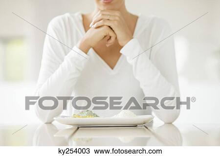 Woman sitting at a table with clays on a plate View Large Photo Image Stock Image - Woman sitting at a table with clays on a plate. Fotosearch