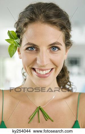 Woman smiling and wearing vegetable leaves in the kitchen View Large Photo Image Picture - Woman smiling and wearing vegetable leaves in the kitchen. Fotosearch