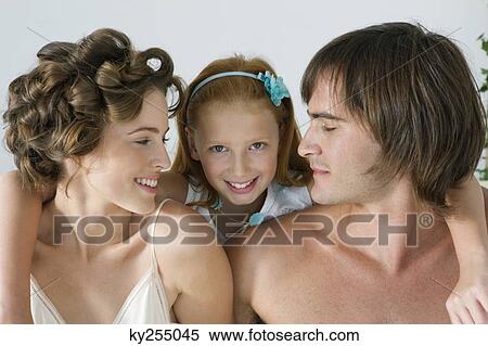 Close-up of a couple smiling with their daughter View Large Photo Image Stock Photography - Close-up of a couple smiling with their daughter. Fotosearch