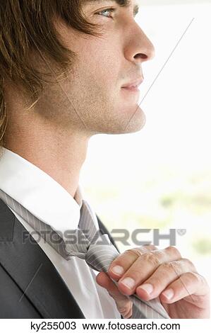 Close-up of a groom adjusting his tie View Large Photo Image Stock Image - Close-up of a groom adjusting his tie. Fotosearch