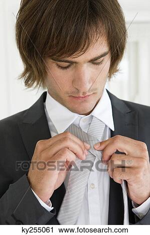 Close-up of a groom adjusting his tie View Large Photo Image Stock Image - Close-up of a groom adjusting his tie. Fotosearch