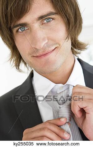 Close-up of a groom adjusting his tie View Large Photo Image Stock Photography - Close-up of a groom adjusting his tie. Fotosearch