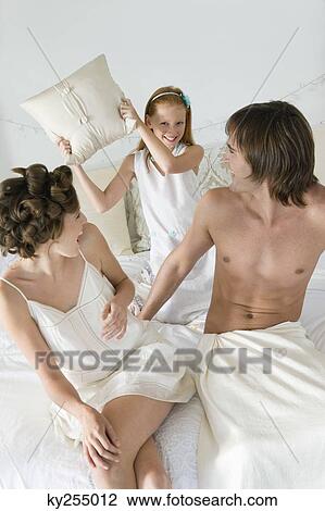 Couple playing with their daughter on the bed View Large Photo Image Stock Image - Couple playing with their daughter on the bed. Fotosearch