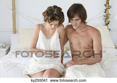 Couple sitting on the bed View Large Photo Image Stock Image - Couple sitting on the bed. Fotosearch