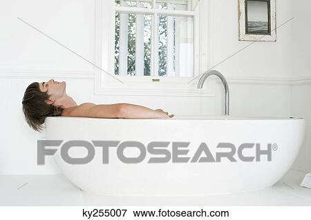 Man lying in a bathtub View Large Photo Image Stock Photo - Man lying in a bathtub. Fotosearch