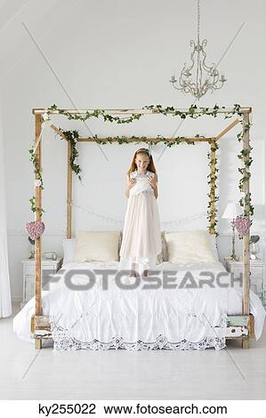 Portrait of a girl standing on the bed View Large Photo Image Stock Image - Portrait of a girl standing on the bed. Fotosearch