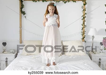Portrait of a girl standing on the bed View Large Photo Image Stock Photo - Portrait of a girl standing on the bed. Fotosearch