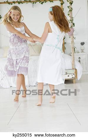 Stock Photography - Two flower girls playing in a bedroom. Fotosearch