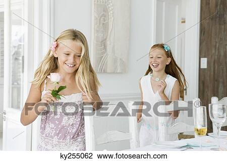 Two girls playing at a dining table View Large Photo Image Stock Image - Two girls playing at a dining table. Fotosearch