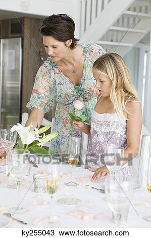 Woman arranging a table for a party with her daughter View Large Photo Image Stock Image - Woman arranging a table for a party with her daughter. Fotosearch
