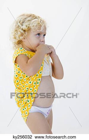 Girl biting her dress View Large Photo Image Stock Image - Girl biting her dress. Fotosearch