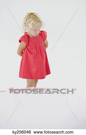Girl holding a doll and looking serious View Large Photo Image Stock Photograph - Girl holding a doll and looking serious. Fotosearch