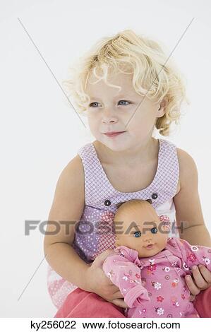 Girl holding a doll View Large Photo Image Stock Image - Girl holding a doll. Fotosearch