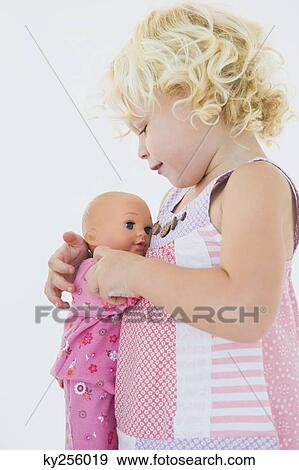 Girl hugging a doll View Large Photo Image Stock Photo - Girl hugging a doll. Fotosearch