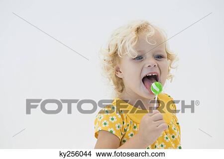 Girl licking green lollipop View Large Photo Image Picture - Girl licking green lollipop. Fotosearch