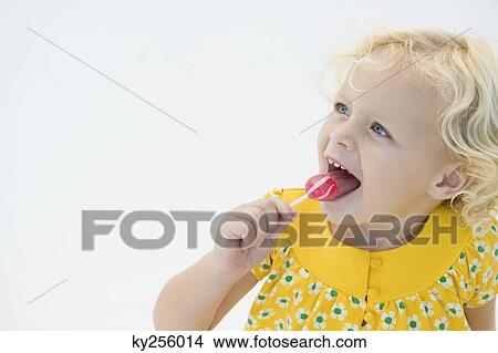 Girl licking red lollipop View Large Photo Image Picture - Girl licking red lollipop. Fotosearch