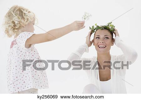Girl putting a wreath on her mother's head View Large Photo Image Stock Photo - Girl putting a wreath on her mother's head. Fotosearch