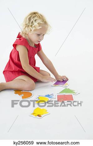 Stock Photo - Girl solving a jigsaw puzzle. Fotosearch