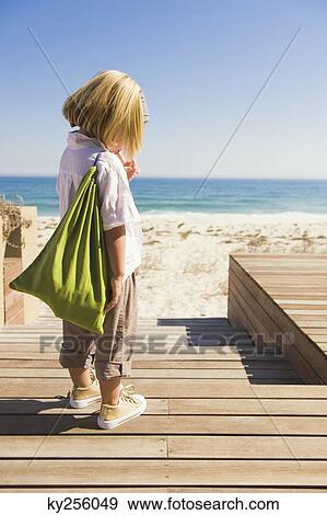 Girl standing on a boardwalk View Large Photo Image Stock Photo - Girl standing on a boardwalk. Fotosearch
