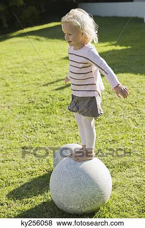Girl standing on a round stone View Large Photo Image Stock Photo - Girl standing on a round stone. Fotosearch