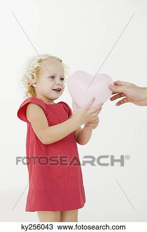 Girl taking a heart shape balloon View Large Photo Image Stock Image - Girl taking a heart shape balloon. Fotosearch
