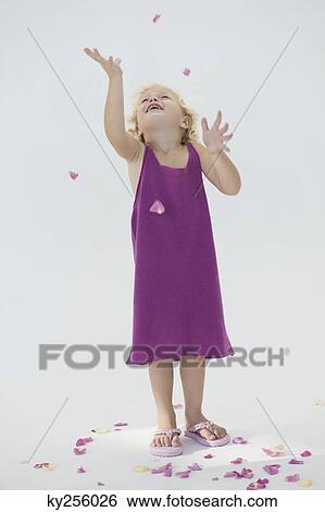 Girl tossing flower petals and smiling View Large Photo Image Stock Photograph - Girl tossing flower petals and smiling. Fotosearch